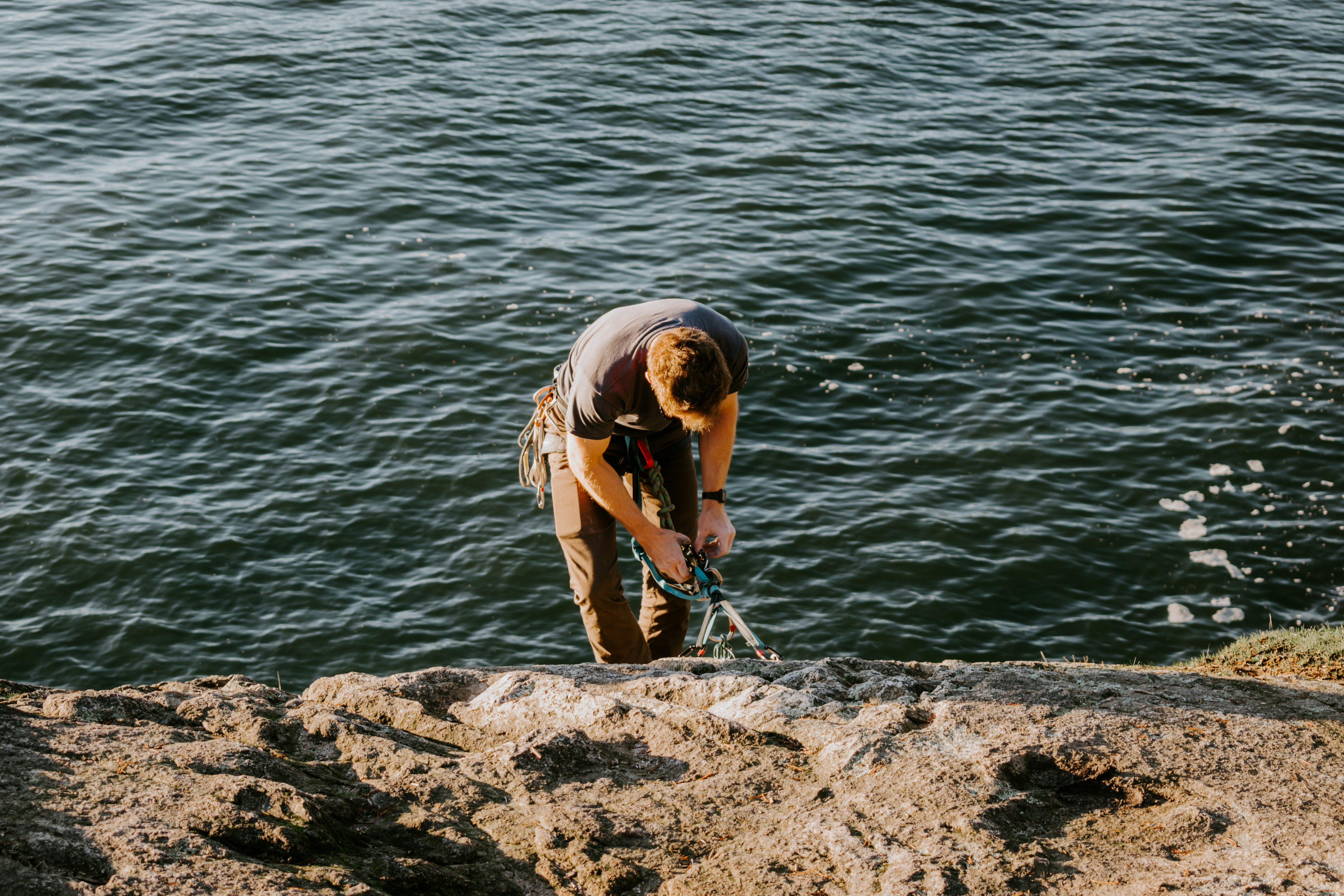 man standing on rock near body of water